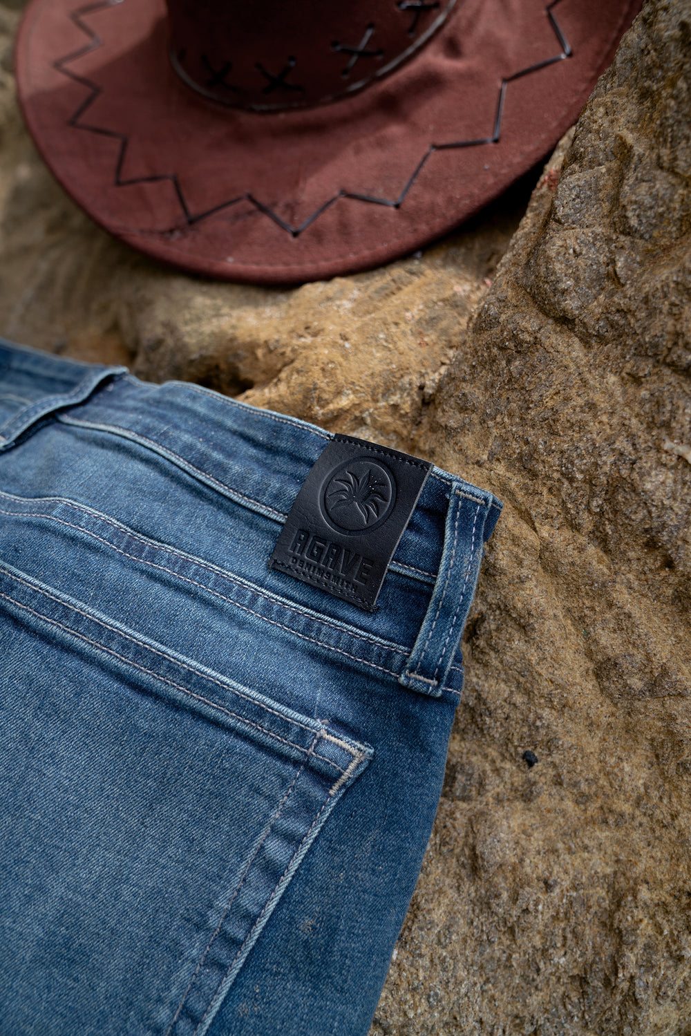 Pair of Agave Denim Jean on a Rock near a beach with a hat