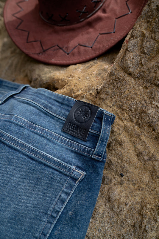 Pair of Agave Denim Jean on a Rock near a beach with a hat